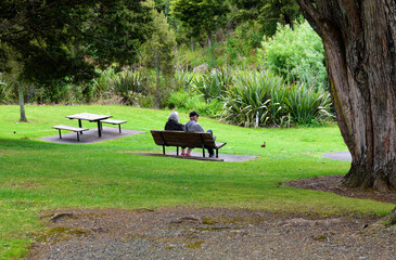 Couple sitting on the bench in the park.