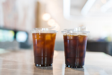 Two glasses of iced black coffee on a marble table at coffee shop.