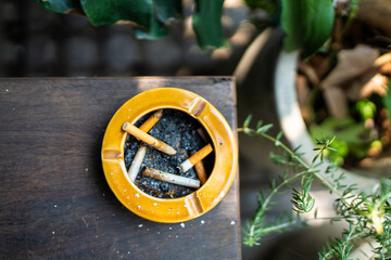 Close up shot of cigarette butts in ceramic ashtray