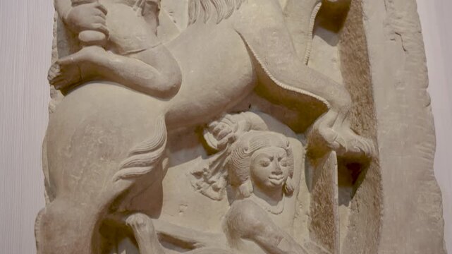 ancient stone relief showing riding on a Leogriph at indoor