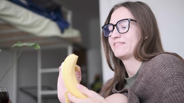 Woman pealing banana at home in casual morning atmosphere, healthy breakfast