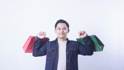 Portrait of Asian man carrying shopping bags in both hands isolated on white background