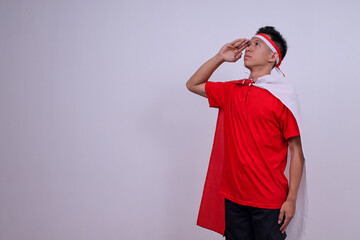 Young Indonesian Man Saluting With Proud And Respectful Expression Looking Upward