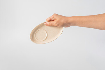 Oval white plate in hand on white background