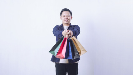 Portrait of happy Asian man with many shopping bags isolated on white background