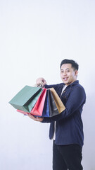 Portrait of Asian man holding many shopping bags isolated on white background