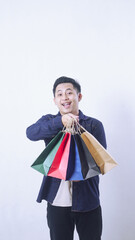 Portrait of happy Asian man holding many shopping bags isolated on white background
