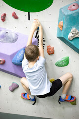 child at indoor climbing wall. Kid having fun at bouldering wall. Child learning at climbing class. Sports healthy lifestyle. climbing summer camp