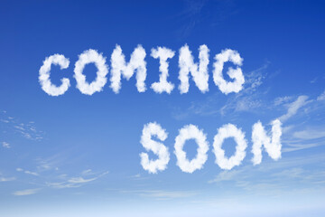 COMING SOON white cloud text on fluffy cloudy bright blue sky