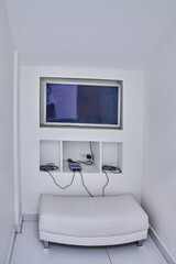 Dental clinic play corner for children featuring a cozy white bench, retro set-top box, and...