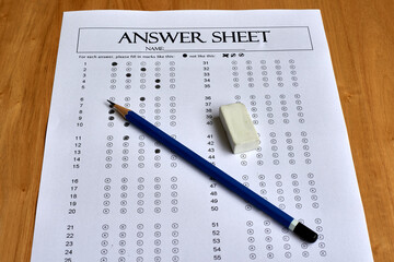Answer Sheet With Filled Response Bubbles and Pencil Placed on Wooden Table Surface During Exam...