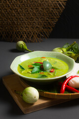 Asian Food concept Authentic Thai chicken Green Curry and thai green eggplant on wooden board with copy space