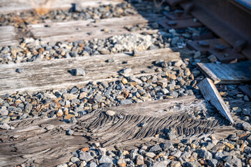 Damaged section of railroad tracks with aged wooden ties