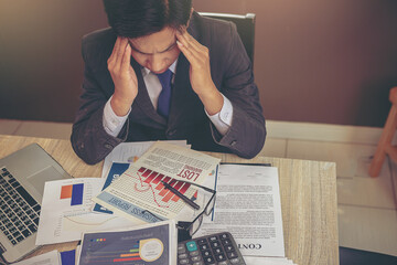 Businessman suffering headache from business disappointed and seriously by bad business results