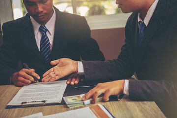 Businessman puts signature on contract at business meeting after negotiations with business...