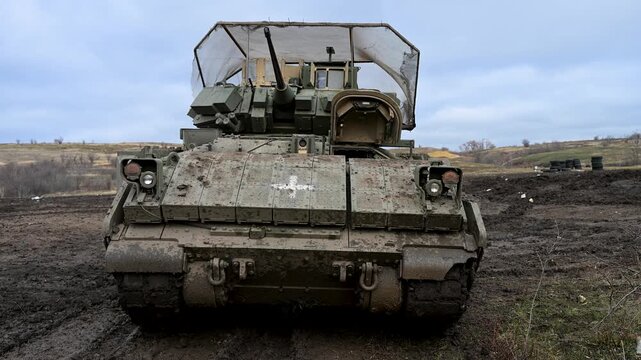 A US-made M2 Bradley, adapted for Ukraine's modern battlefield. The medical cross shows its CASEVAC role, while cage armor is a key modification for defense against drones.
