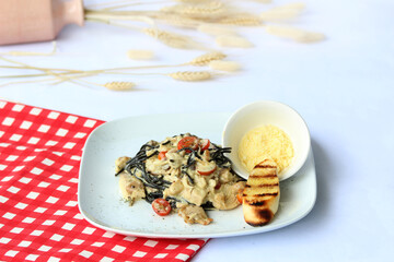 fold fresh squid ink into cooked pasta, coating the noodles with its striking, briny flavors. Served with sautéed calamari, garlic and lemon