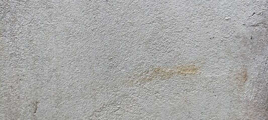 White Rough Plaster Wall Texture. Close-up texture of a white rough plaster wall with slight stains...