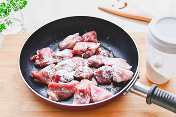 下味をつけた豚肉に粉をふるう