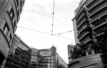 Modern office buildings and string lights creating urban geometry in monochrome