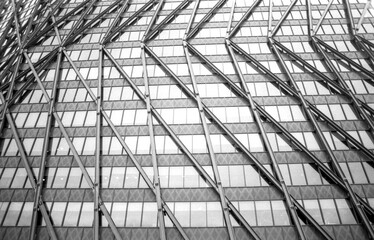 Modern architecture glass and steel facade reflecting city skyline in monochrome