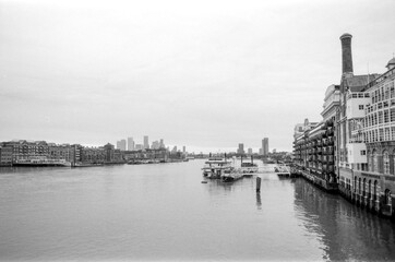 Grainy monochrome cityscape of london featuring river thames and canary wharf