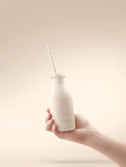 Hand holding a bottle of milk with straw on light pastel solid background, super realistic cinematic style with dramatic lighting and neutral colors, healthy drink concept.