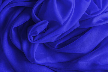 bright blue folds of silk fabric. blue silk texture. beautiful festive background. layout for...