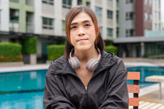 Transgender non binary woman relaxing poolside in healthy lifestyle concept during summer