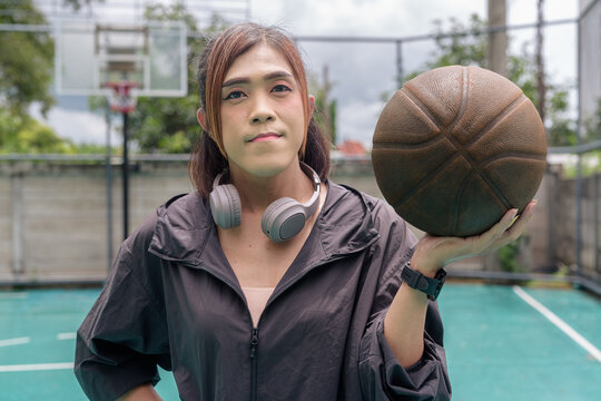 Transgender non binary woman posing confidently on outdoor basketball court - Powered by Adobe
