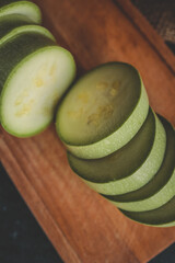 Sliced bottle gourd on wooden cutting board with whole gourds in burlap sack. Fresh green vegetable...