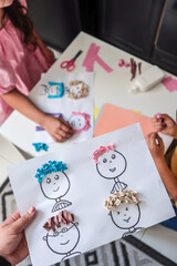 Children making creative paper art with cartoon faces and textured hair from crumpled colored...