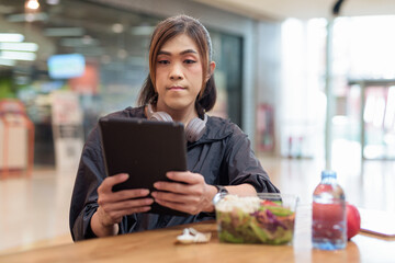 Transgender non binary woman eating healthy salad in restaurant