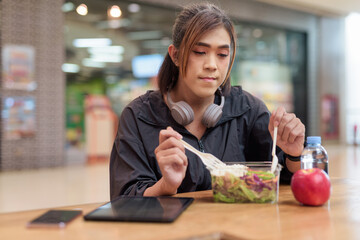 Transgender non binary woman eating healthy salad in restaurant