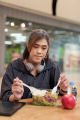Transgender non binary woman eating healthy salad in restaurant
