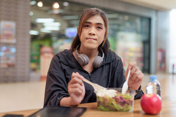 Transgender non binary woman eating healthy salad in restaurant