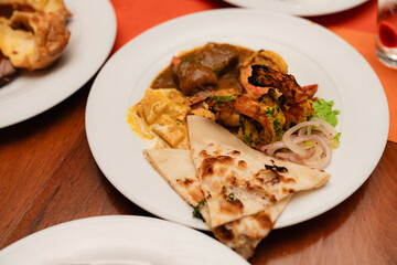 Indian Cuisine Buffet Plate with Grilled Prawns, Curry, Paneer and Naan