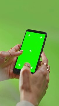 Female hands using smartphone with green screen, chroma key for app design, technology, communication