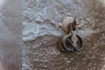 ronda,malaga,spain Close-up of an ancient metal door featuring a distinctive bull-shaped knocker,...