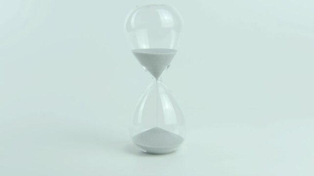 Temporal dissonance written on a yellow sticky note placed on an hourglass, symbolizing the conflict or misalignment between perceived and actual passage of time