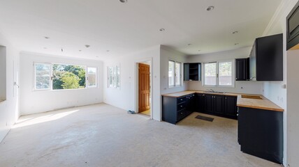 Fototapeta premium Modern open concept kitchen design with black cabinets and white walls in a bright and spacious home interior