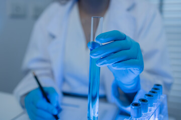 Fototapeta premium a female chemist is testing various liquid compounds in a lab, a scientist is doing research on the development of science in a lab, laboratory, test tube, scientific