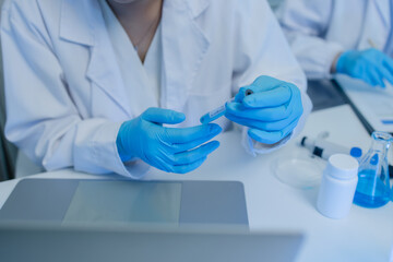a female chemist is testing various liquid compounds in a lab, a scientist is doing research on the...