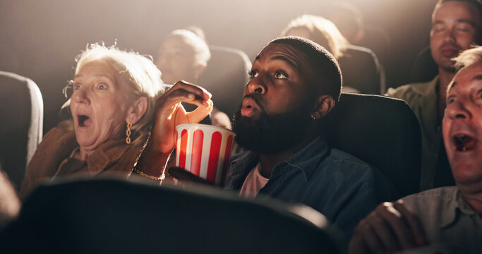 Popcorn, man and movie in theater with shock for horror scene, thriller premiere and entertainment. Film screening, audience and snack with terror in cinema for scary show, fear and intense storyline - Powered by Adobe