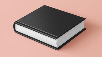 A closed, black hardcover book with a slightly textured cover rests on a pale pink surface, its white pages visible along the spine.  A subtle shadow is cast beneath