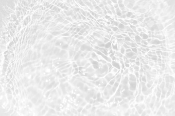 White water with ripples on the surface. Defocus blurred transparent white colored clear calm water surface texture with splashes and bubbles. Water waves with shining pattern texture background.