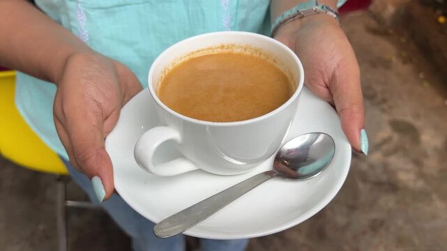 Darjeeling milk tea served in a white saucer in India