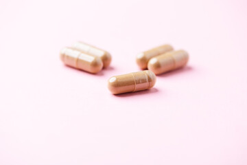 Ginseng capsules on bright background. Soft focus. Close up. Copy space	