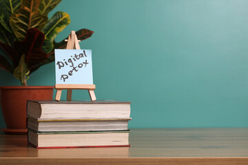 Digital detox reminder displayed on easel resting on stack of books