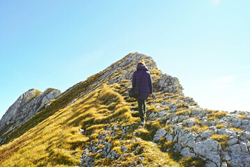 Photographed from behind, a female tourist is hiking along a scenic trail on Mount Sedlena Greda in...